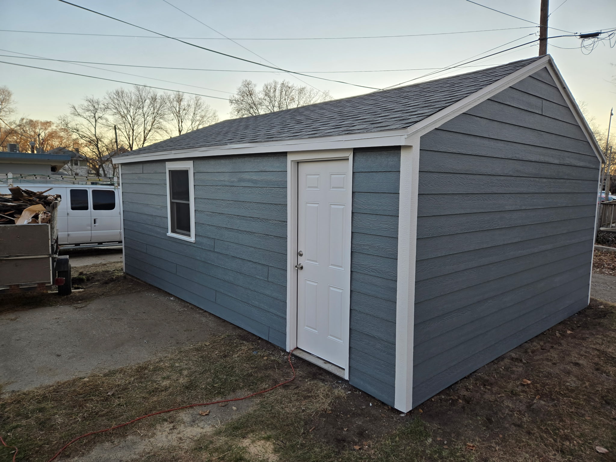 Residential exterior painting - grey shed with white trim and door